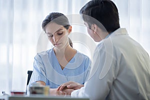 A doctor takes care of a sick patient woman with sadness and unhappiness at the hospital or medical clinic