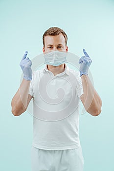 Doctor takes off the medical mask in clinic on light blue background. Healthy concept