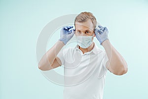 Doctor takes off the medical mask in clinic on light blue background. Healthy concept