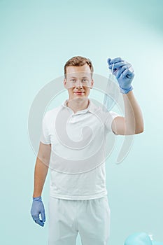 Doctor takes off the medical mask and smilling in clinic on light blue background. Healthy concept