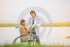 Doctor takes a patient on wheelchair