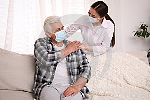 Doctor taking care of senior man with mask at nursing home