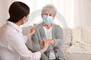 Doctor taking care of senior woman with protective mask at nursing home