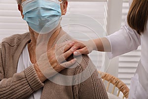 Doctor taking care of senior woman with protective mask at nursing home, closeup