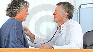 Doctor taking the heartbeat of his mature patient