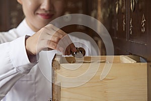 Doctor Taking Herb Used for Traditional Chinese Medicine Out of a Drawer