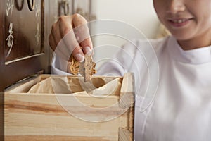 Doctor Taking Herb Used for Traditional Chinese Medicine Out of a Drawer