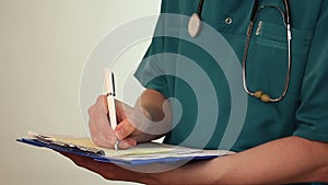 Doctor taking notes on clipboard, filling medical form, report