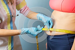 Doctor taking obese woman`s body fat measurements photo