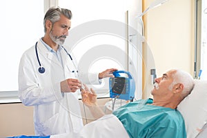 Doctor taking patient's pulse with electronic device
