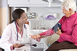 Doctor Taking Senior Female Patient's Blood Pressure