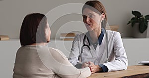 Doctor talk to 60s patient touch her hand provide support