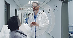 Doctor talking with patient in hospital corridor 4k