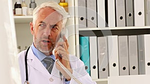 Doctor talking on the phone at his desk