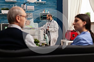 Doctor talking to elderly patient in hospital room