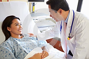 Doctor Talking To Female Patient On Ward