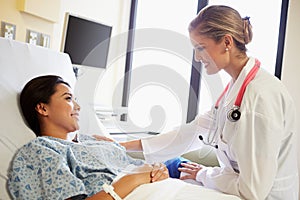 Doctor Talking To Female Patient On Ward