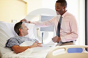 Doctor Talking To Male Patient In Hospital Room