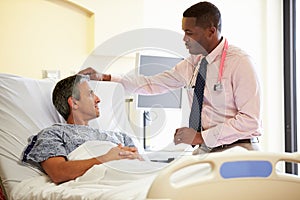 Doctor Talking To Male Patient In Hospital Room