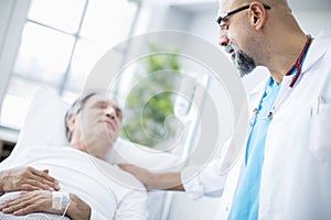 Doctor talking to patient in hospital bed