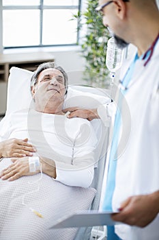 Doctor talking to patient in hospital bed