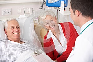 Doctor talking to senior couple in hospital