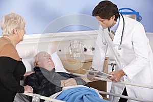 Doctor talking to senior couple in hospital