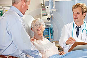 Doctor Talking To Senior Couple On Ward