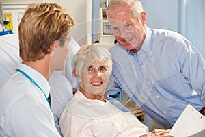 Doctor Talking To Senior Couple On Ward