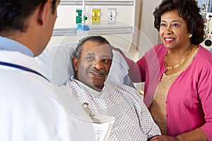 Doctor Talking To Senior Couple On Ward