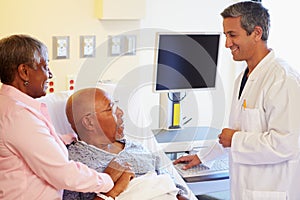 Doctor Talking To Senior Couple On Ward