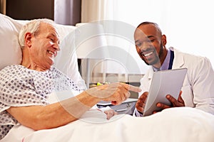 Doctor Talking To Senior Male Patient In Hospital Bed