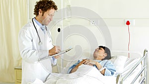 Doctor talking to sick patient in bed
