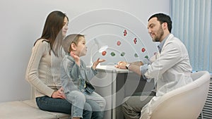 Doctor talking to young child and mother