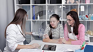 Doctor talking to young child and mother