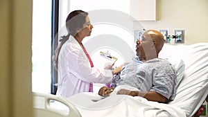 Doctor Talks To Senior Male Patient In Hospital Room