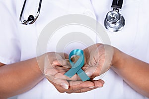 Doctor With Teal Ribbon Showing Ovarian Cancer Awareness photo