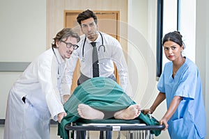 Doctor team and nurse staff carrying stretcher with patient from the accident ambulance running to the surgery room in hospital