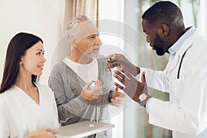 The doctor tells the nurse how an elderly male patient should take pills.