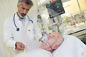 Doctor tending to patient wearing oxygen mask