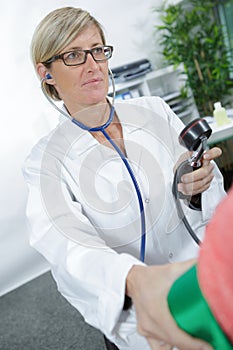 Doctor testing blood pressure to senior patient