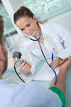 Doctor testing blood pressure to senior patient