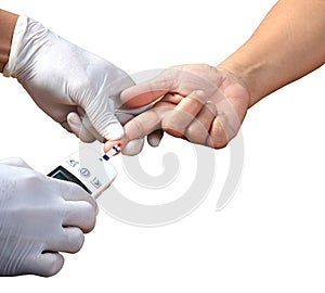 Doctor testing a patients glucose level after pricking his finger to draw a drop of blood and then using a digital glucometer in