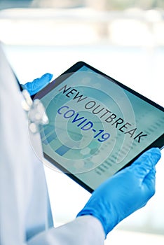 Doctor and text covid-19 new outbreak in a tablet