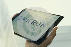 Doctor and text omicron in a tablet photo