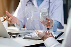 Doctor therapist consulting male patient about pills. Doctor prescribing medicine sitting at the desk in the Hospital.