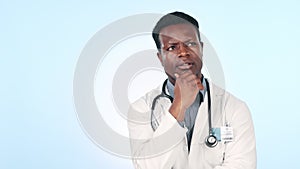 Doctor, thinking and man problem solving with an idea, solution or inspiration on blue background in studio. Medicine