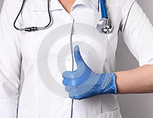 Doctor with thumb up gesture. Good health, trust in medical professional competence concept. Woman in lab coat and in