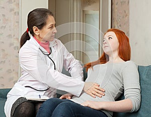 Doctor touches belly of teenage patient