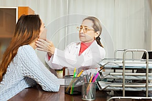 Doctor touching gland of female patient